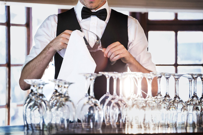 mann der Weingläser poliert